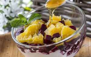 Викладіть інгредієнти шарами в широкі порційні стаканчики, чергуючи сир, буряк та апельсин