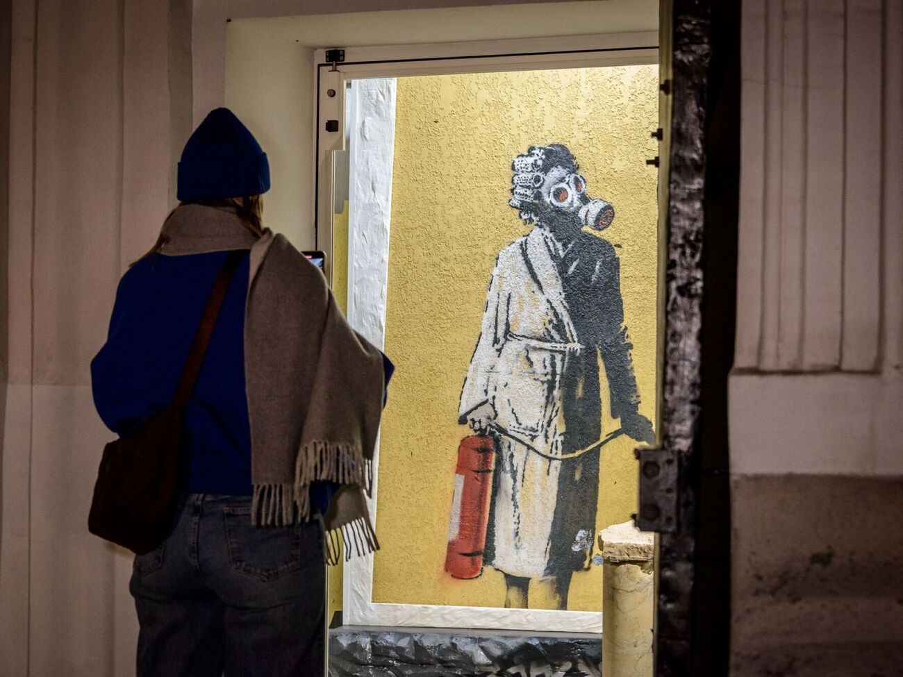 В начале декабря 2023 года восемь человек срезали изображение женщины в противогазе со стены обгоревшего дома в Гостомеле