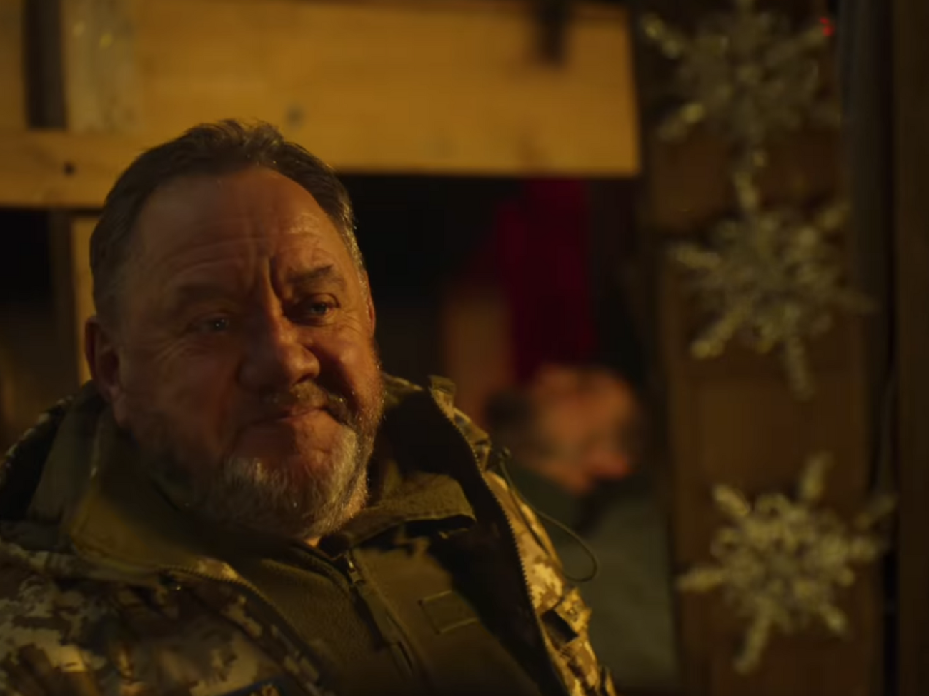 Святий Миколай, якого зіграв український актор Богдан Бенюк, у військовій формі спускається у бліндаж захисників України та зі свого наплічника дістає кожному подарунки