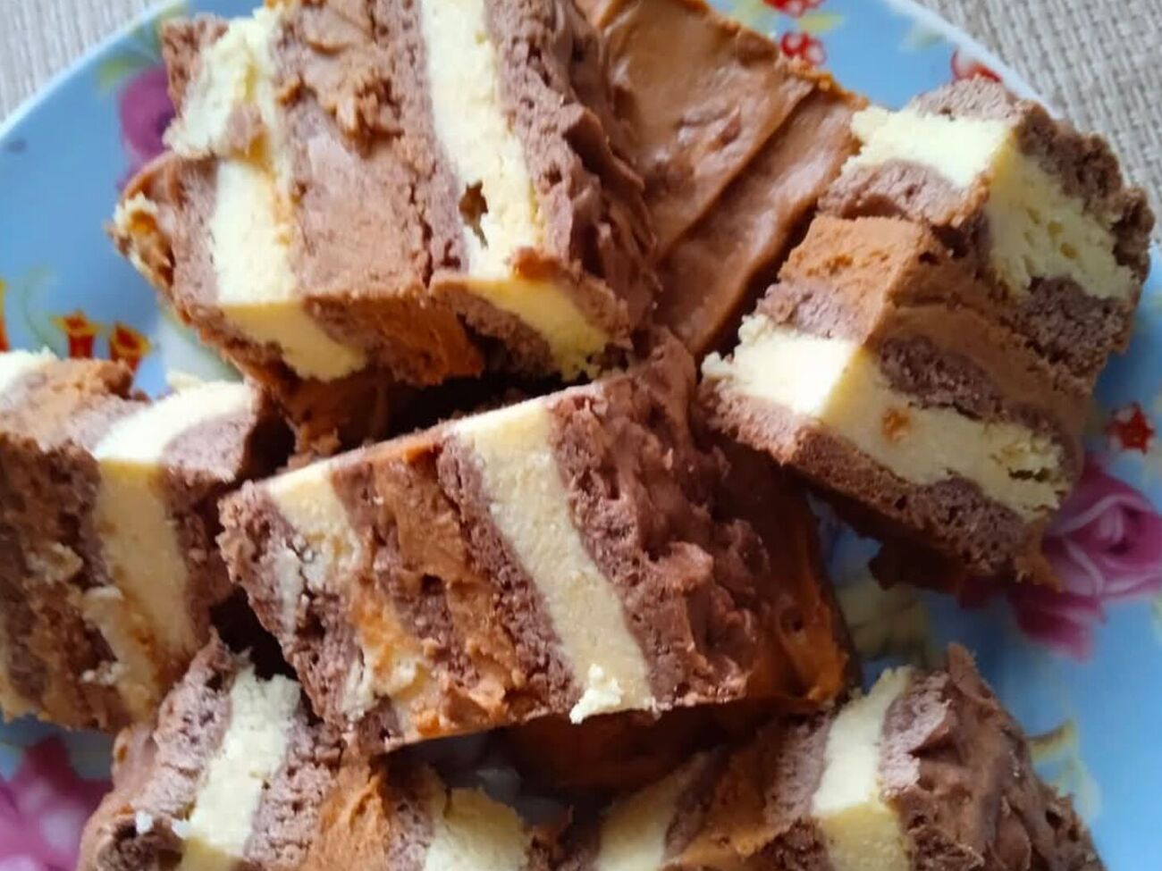 Сочетание творожных коржей и крема со сгущенным молоком напоминает десерт "Сникерс"