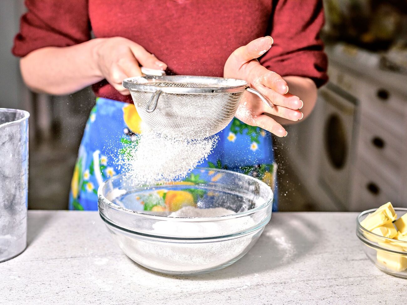 Чтобы стол во время просеивания остался чистым, муку нужно насыпать в мерный стакан