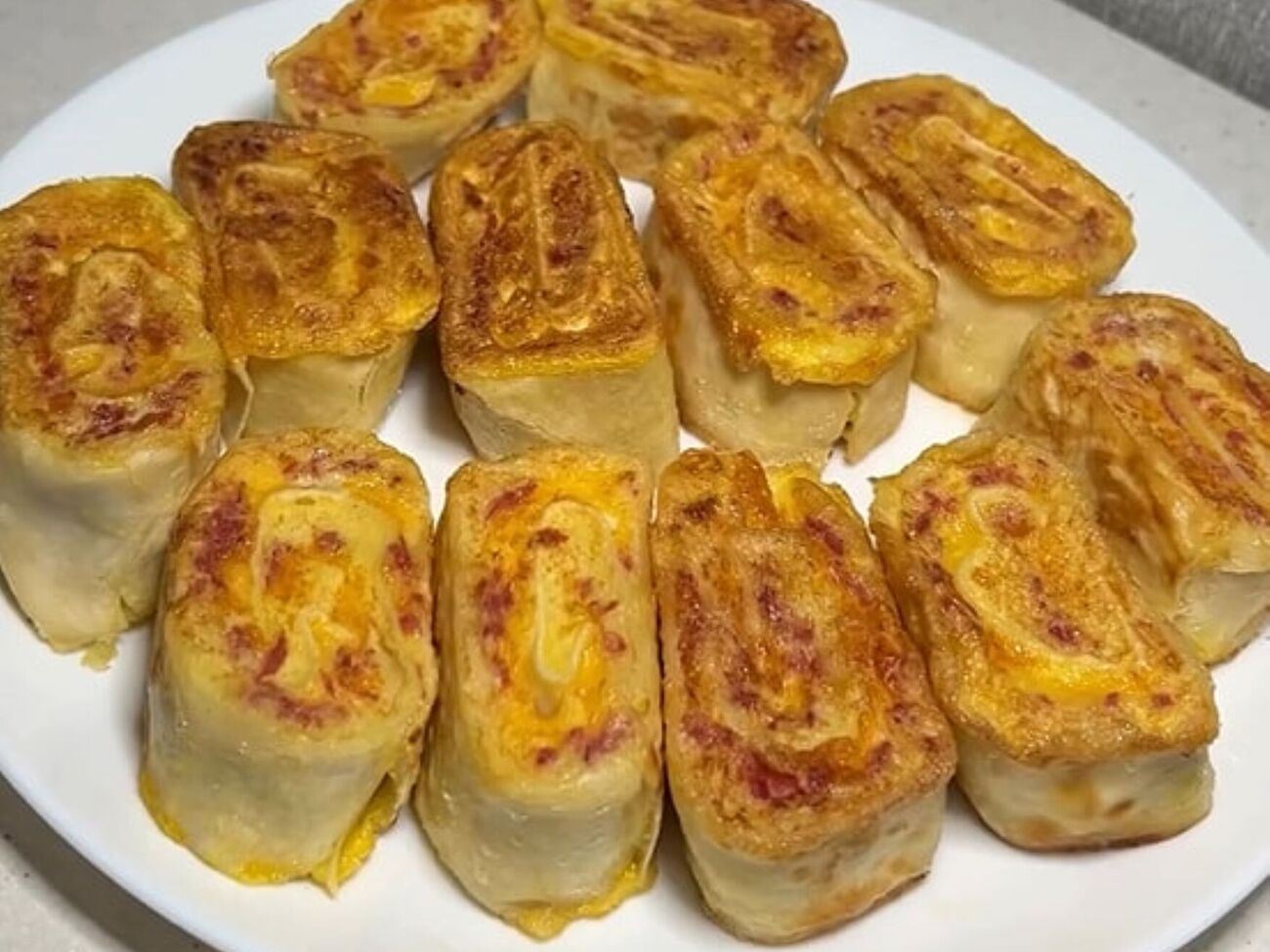 Смочите рулетики в яйце и обжарьте на сковороде