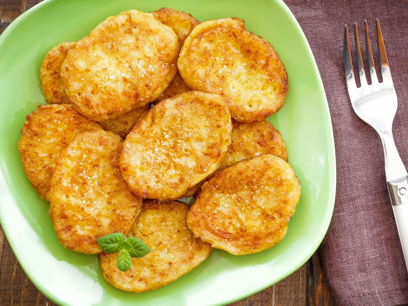 Готовые деруны выложите на противень, застеленный пергаментом, и поставьте в разогретую духовку на 10 минут