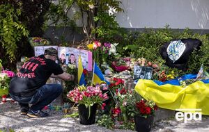 Люди несут цветы к месту убийства украинцев