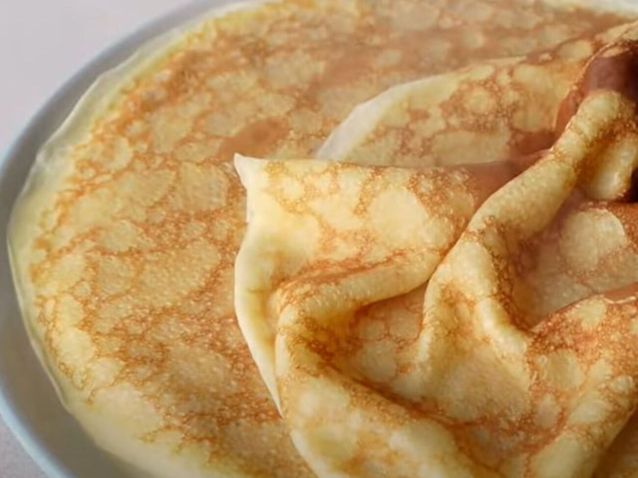 Жарьте блины на разогретой сковороде, смазав ее жиром перед приготовлением только первого блина