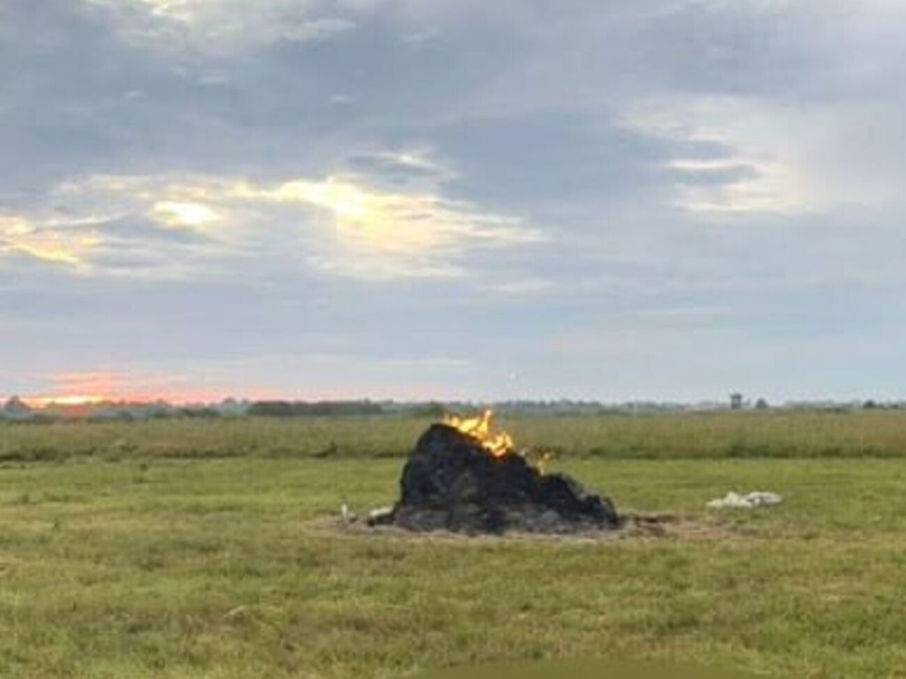 Мужчина вышел на луг, чтобы накрыть стог сена