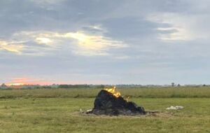 Мужчина вышел на луг, чтобы накрыть стог сена