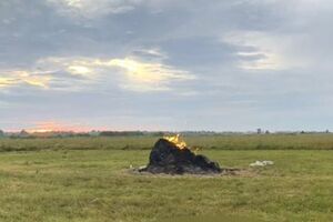 Мужчина вышел на луг, чтобы накрыть стог сена