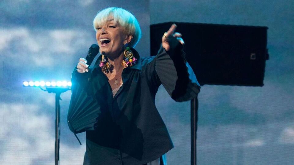 Вайкуле взобралась в обуви на стол с помощью стула, продолжая при этом петь