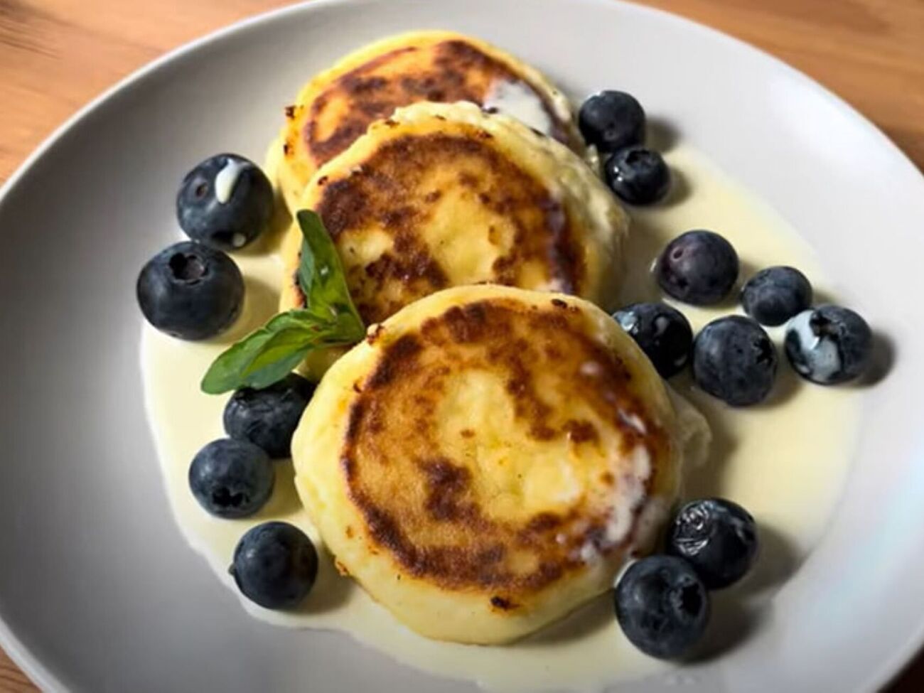 Обжарьте сырники с двух сторон на разогретой сковороде, смазанной растительным маслом