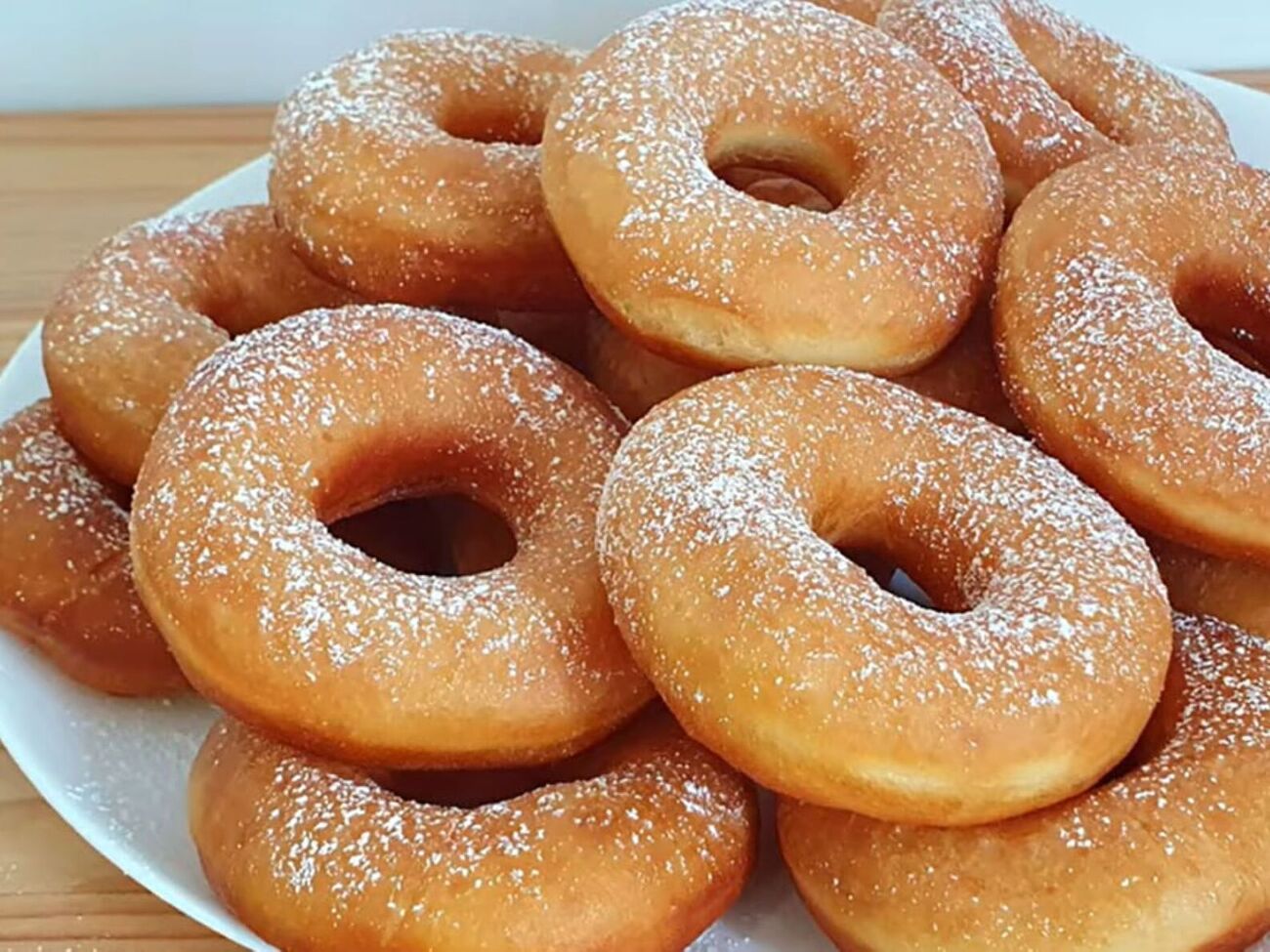 Обсмажте пончики на розігрітій олії на середньому вогні, а потім посипте цукровою пудрою