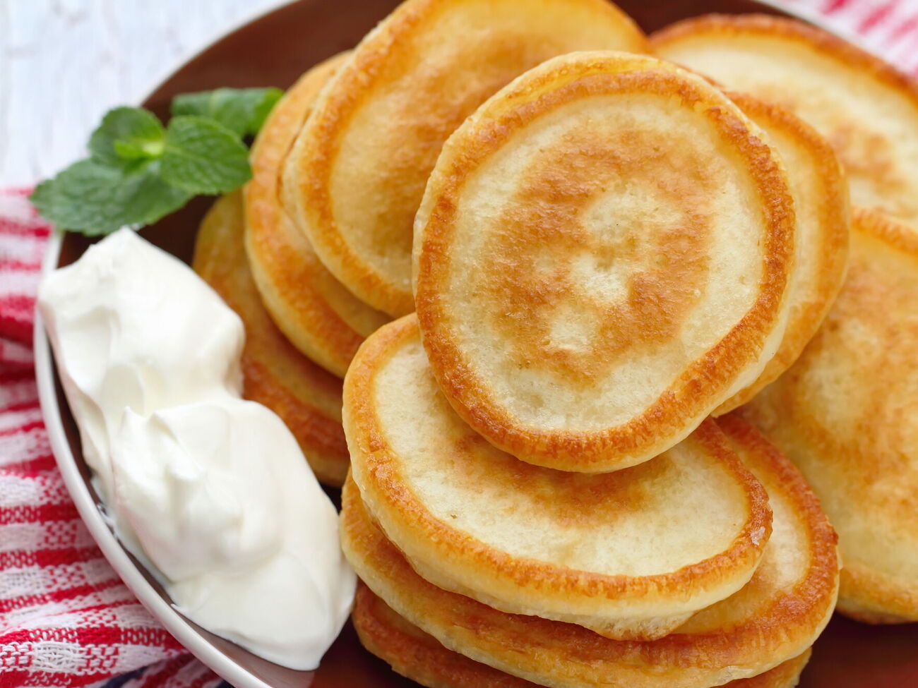 Обжарьте оладьи на разогретой сковороде с растительным маслом под крышкой