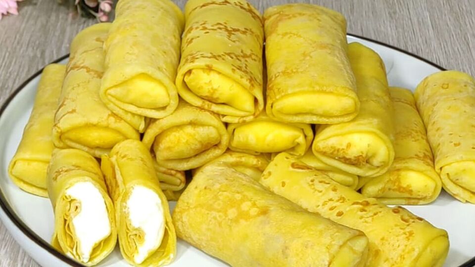 Выложите на каждый блин начинку и сверните рулетиком