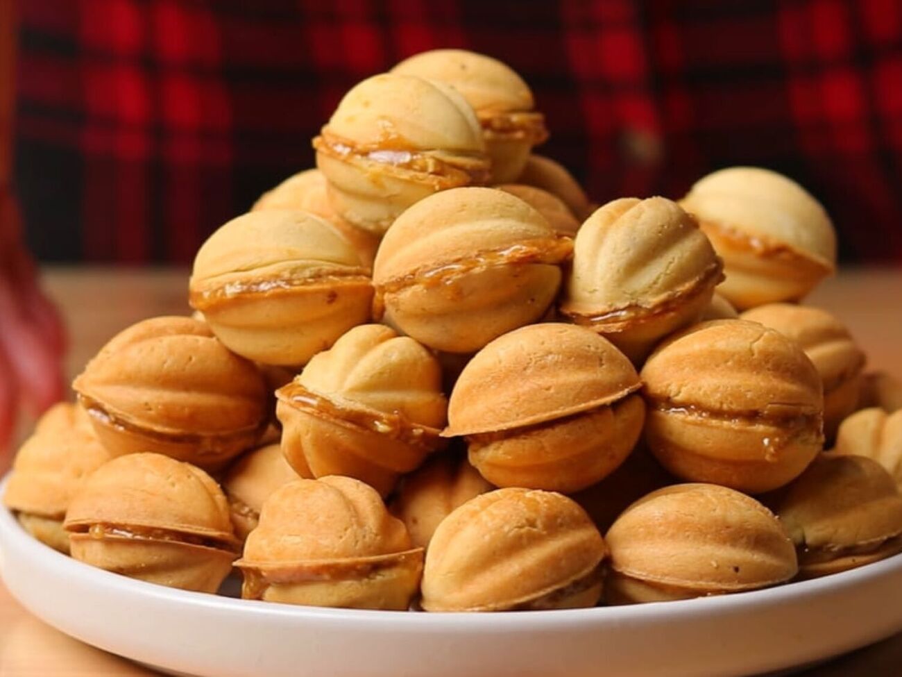 Начините половинки орехов карамелью и накройте второй частью, чтобы они склеились