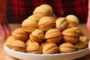 Начините половинки орехов карамелью и накройте второй частью, чтобы они склеились