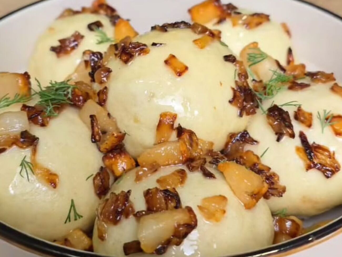 Подавайте галушки зі шкварками і сметаною, присипавши кропом