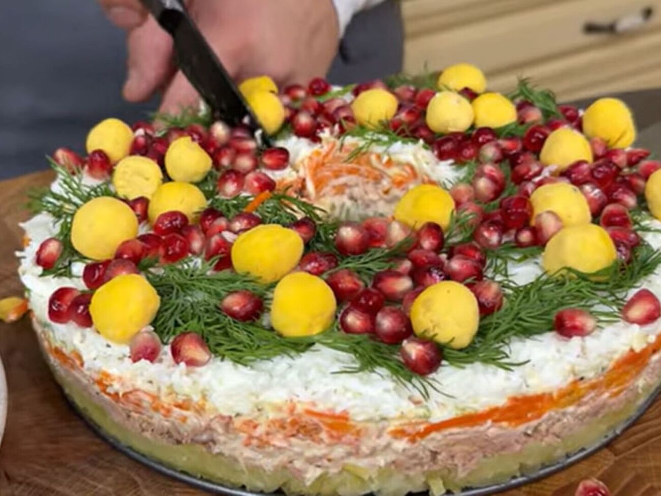 Декорируйте салат зеленым укропом, шариками из желтка и зернами граната