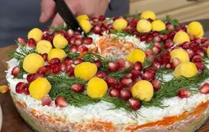 Декорируйте салат зеленым укропом, шариками из желтка и зернами граната