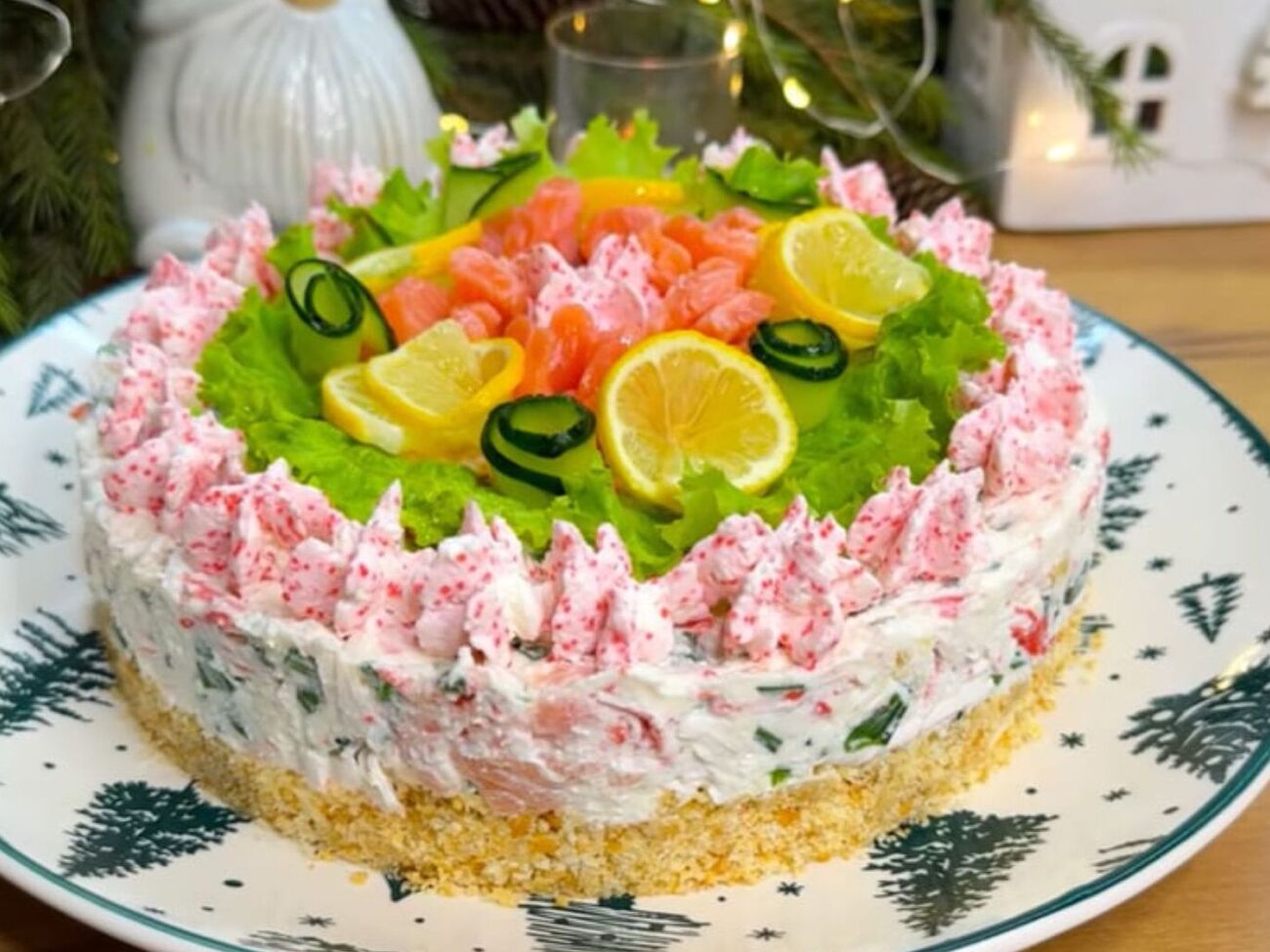 Готовый торт декорируйте листьями салата и розами из красной рыбы