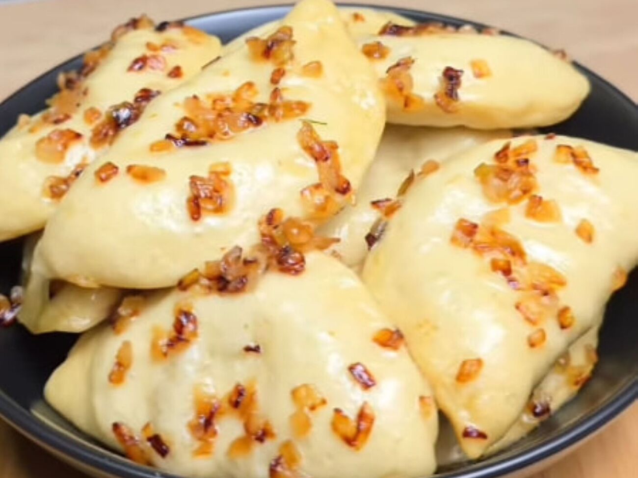 Подавайте вареники, посыпав луком