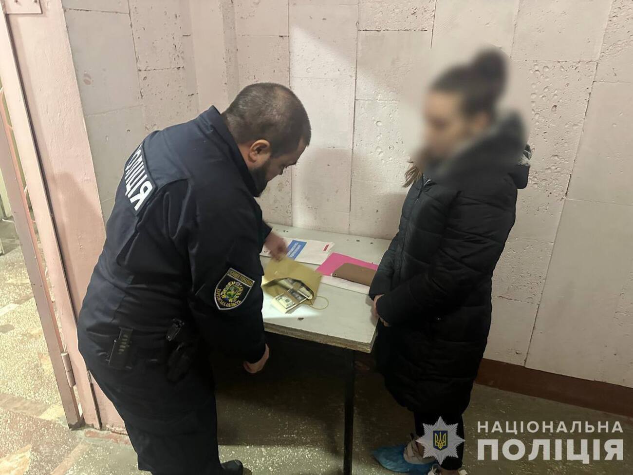 Правоохранители сообщают, что задержали женщину сразу после того, как она получила деньги