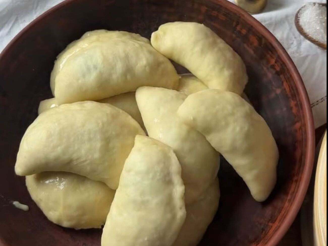 Готовые вареники смажьте сливочным маслом