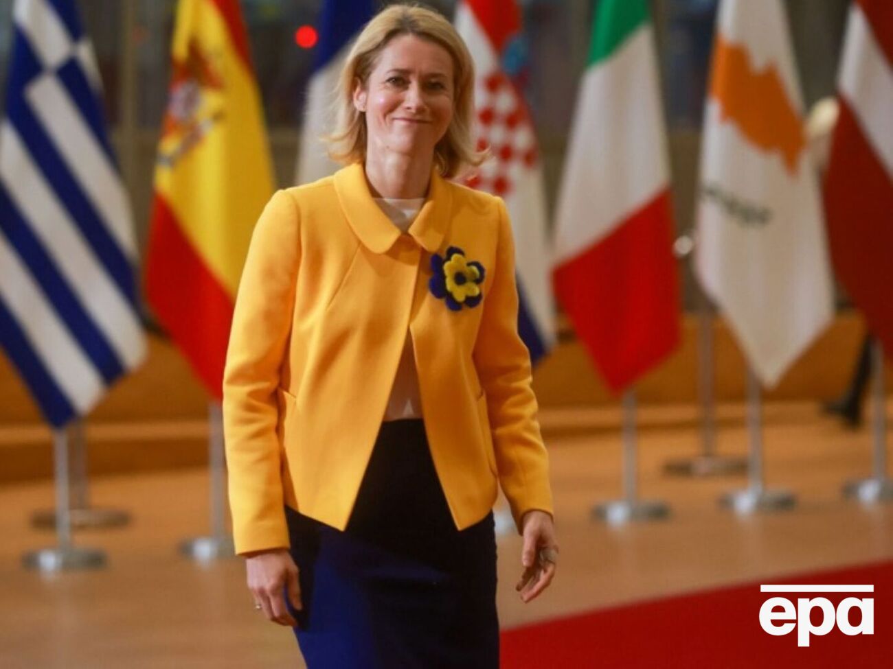 Каллас дополнила свой образ желто-синим цветком, который прикрепила на лацкан пиджака