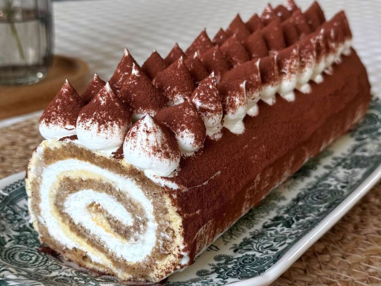 После стабилизации переложите рулет на тарелку и тонким слоем сверху и по бокам смажьте кремом