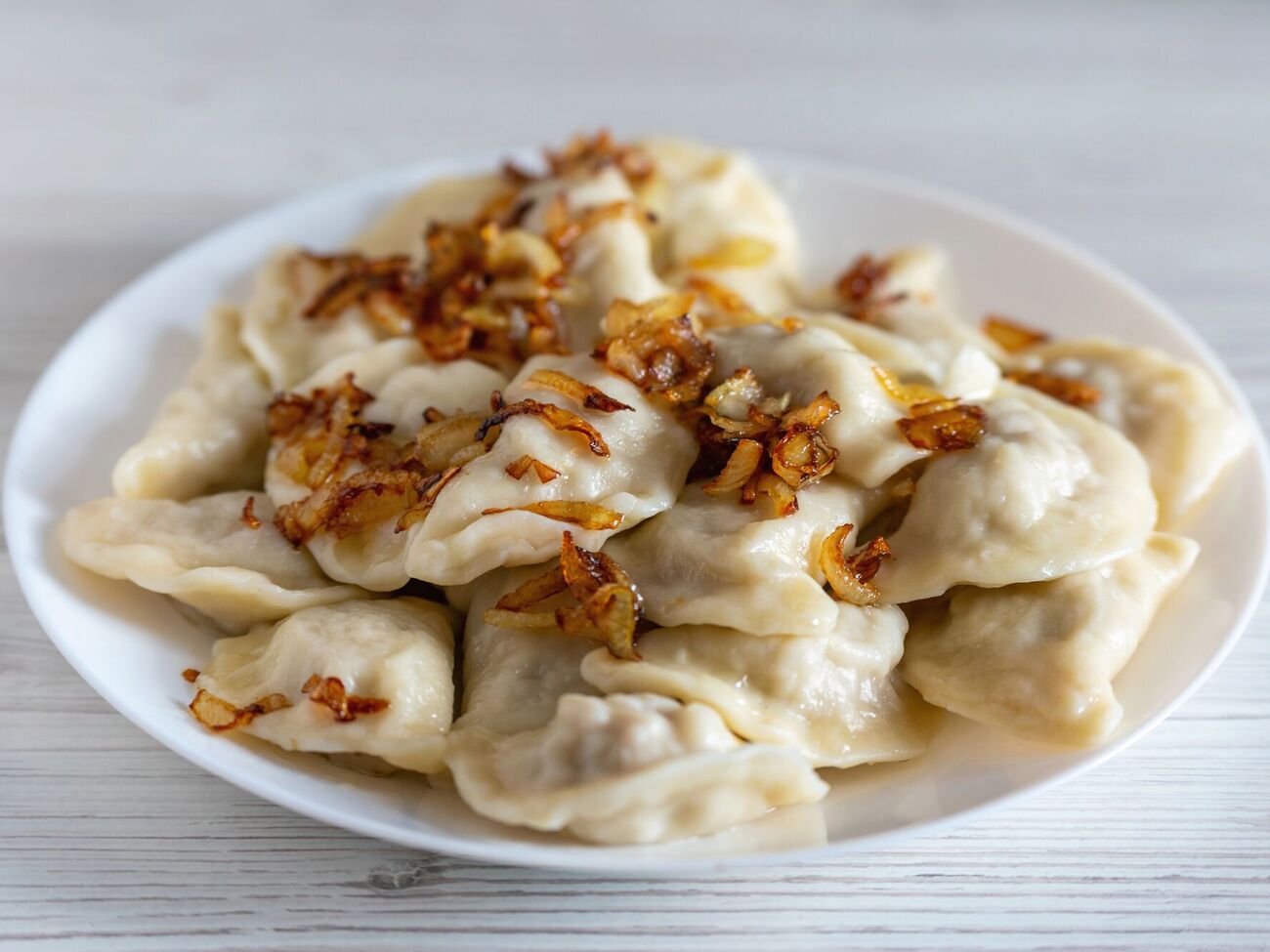 Готовые вареники нужно сразу переложить в глубокую тарелку и сбрызнуть топленым сливочным маслом