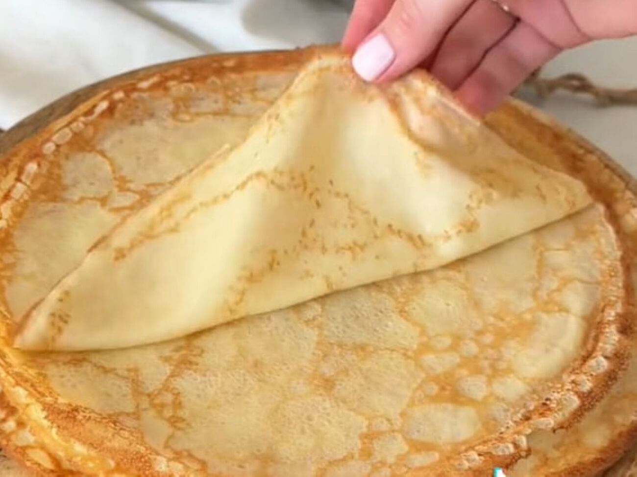 Чтобы у блинов не было сухих краев, жарить их нужно очень быстро на среднем огне около одной минуты с каждой стороны