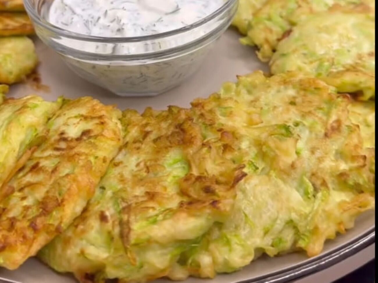 Подавайте оладьи со сметанным соусом с зеленью и чесноком