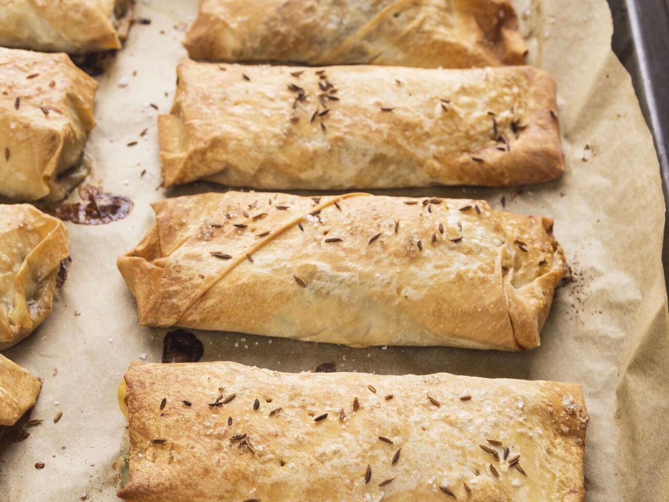 Перед выпеканием пирожки посыпают кунжутом