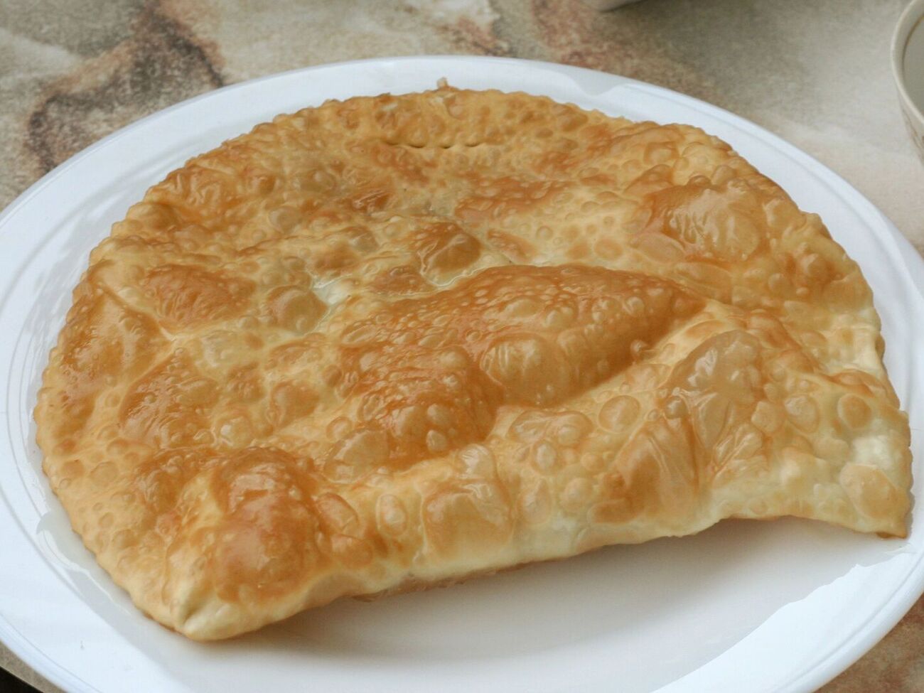 Сформируйте чебуреки и обжарьте их на большом количестве растительного масла с двух сторон