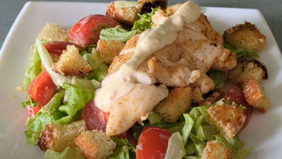 Для салата понадобятся филе курицы, листья салата, сухарики, томаты и соус