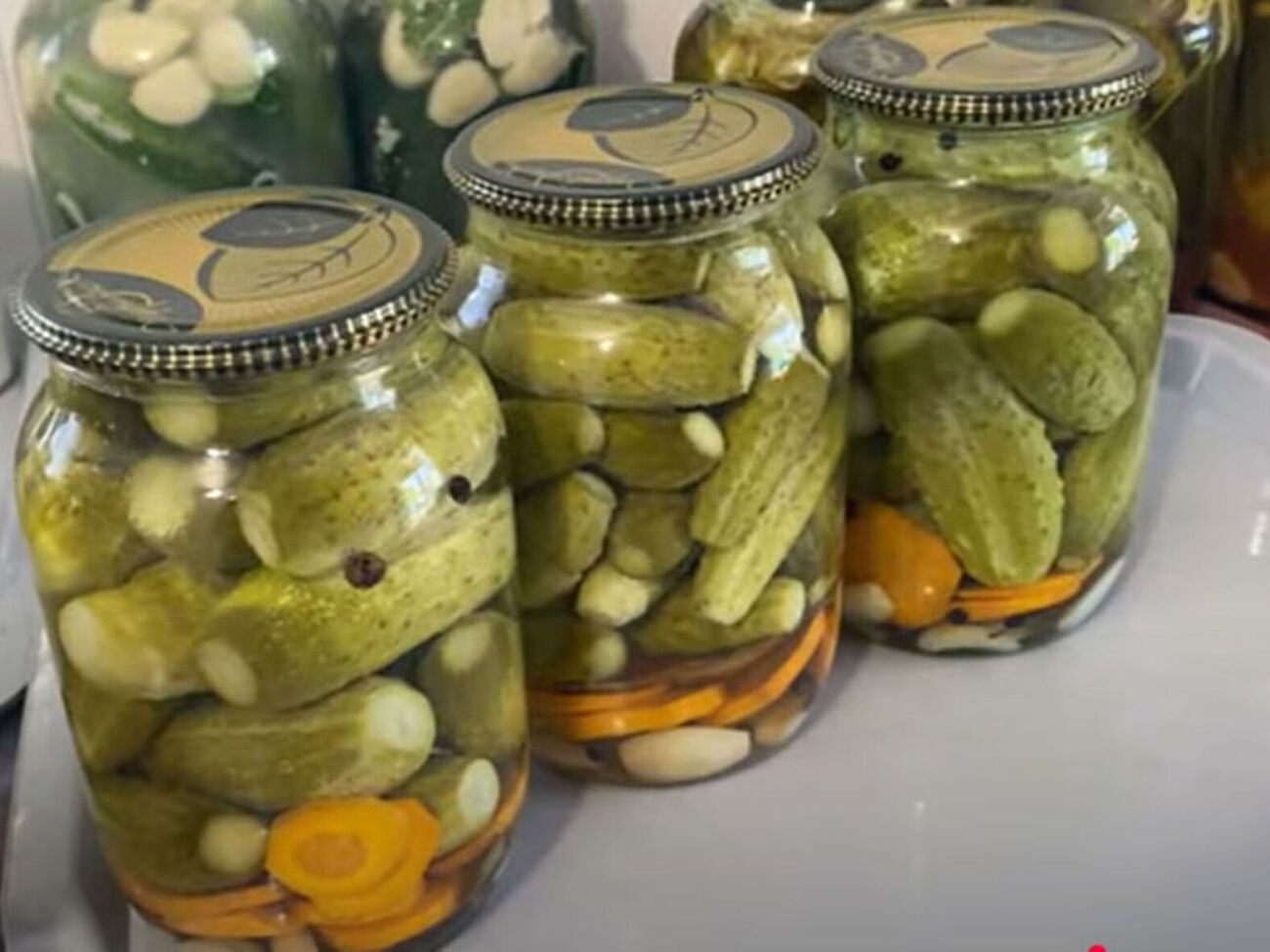 Герметично закройте банки с огурцами крышками, переверните и оставьте под пледом до полного остывания