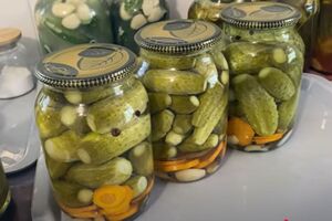 Герметично закройте банки с огурцами крышками, переверните и оставьте под пледом до полного остывания
