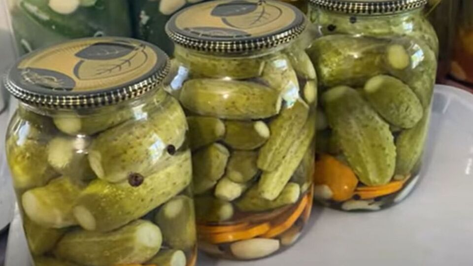 Герметично закройте банки с огурцами крышками, переверните и оставьте под пледом до полного остывания