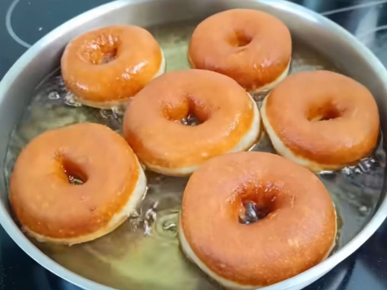 Окуните теплые пончики в глазурь и дайте ей подсохнуть