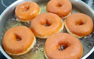 Окуните теплые пончики в глазурь и дайте ей подсохнуть