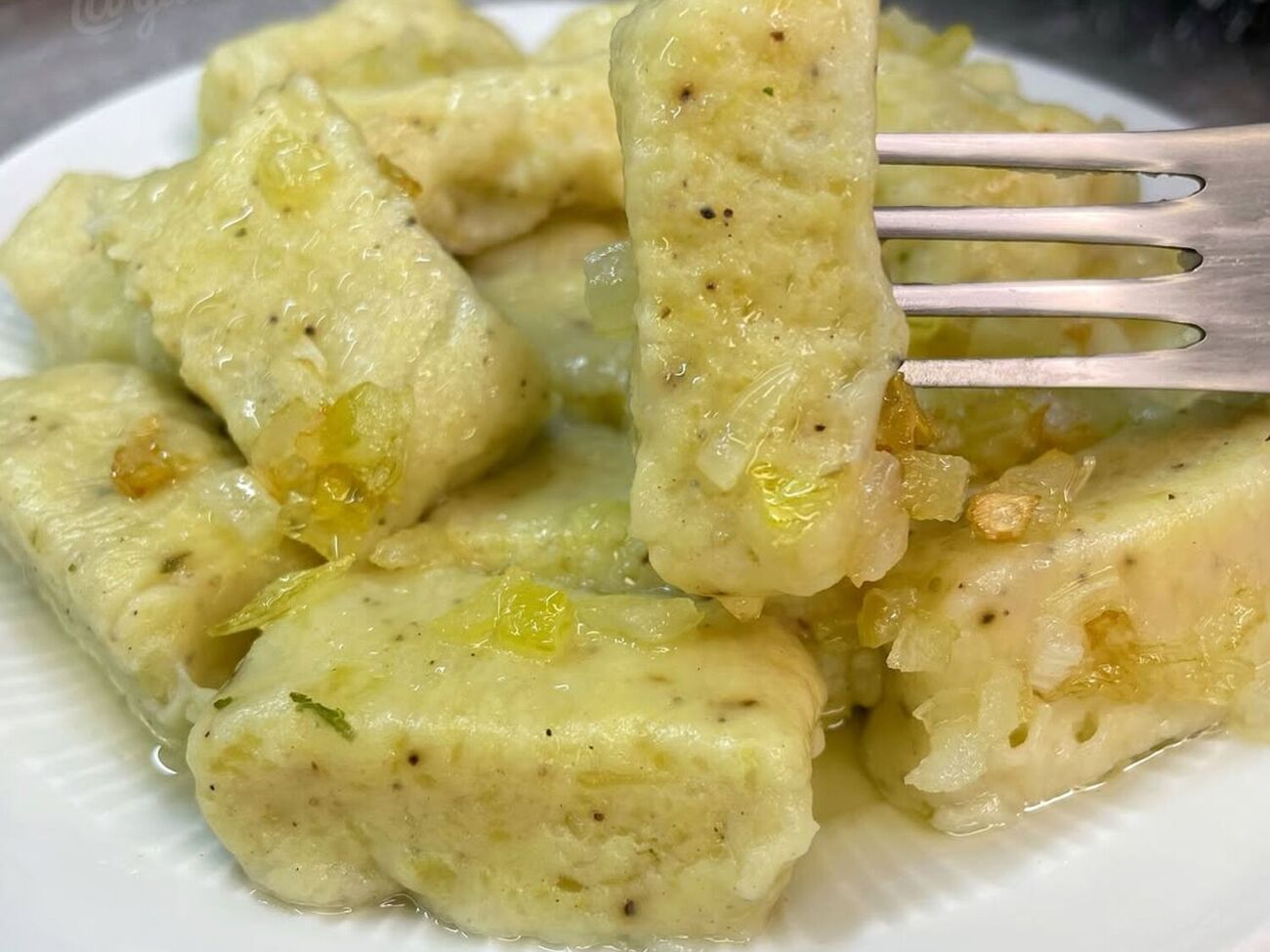 Сварите галушки в подсоленной воде и подавайте горячими с поджаренным луком и беконом